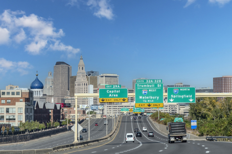 Drivers’ perspective view over Interstate I-91 in northerly direction with downtown Hartford in background and blue dome on the former Colt Firearms factory